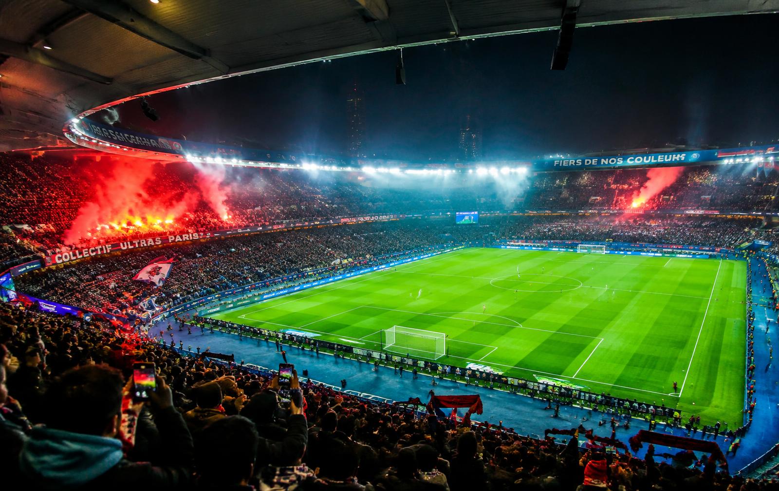 Packed stadium under floodlights